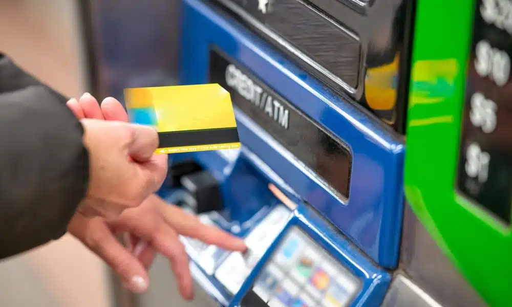 a person using a credit card to pay for a machine