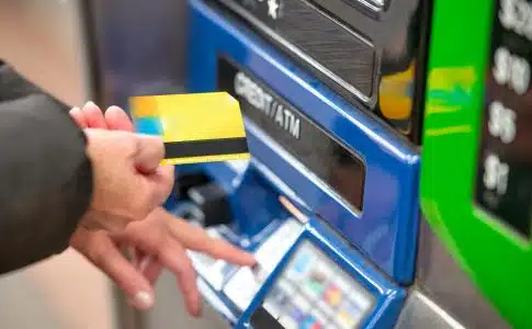 a person using a credit card to pay for a machine